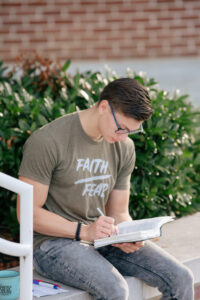 male student doing devotions