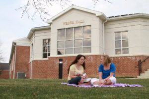 Two students studying outside Webber Hall.