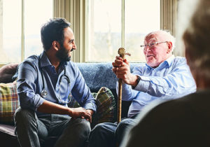 A social worker gives care to an older gentlemen
