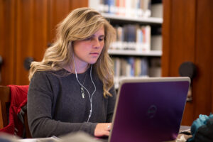 A woman working at a laptop. 