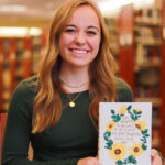 a student holds a bible cover she pained