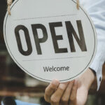 a restaurant staff person flipping a sign to "open"