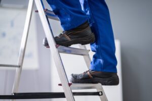 Low Section View Of A Handyman's Foot Climbing Ladder