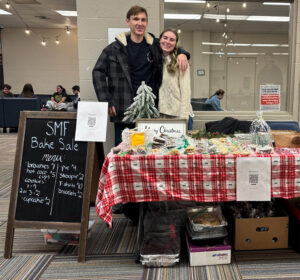 SMF Treasurer Dillon Roth ('27) and President Emily Kocher ('26) helped man the SMF bake sale table in December 2024 to benefit Every Tribe Philippines.