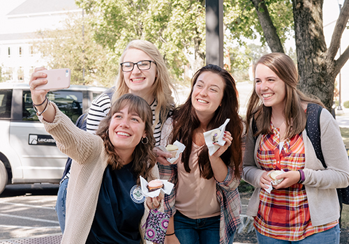 Cheerful students taking a selfie at homecoming.