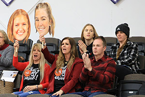 parents in the stands cheering for their daughters on the court.