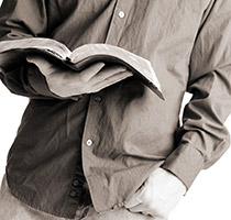 man standing holding an open Bible