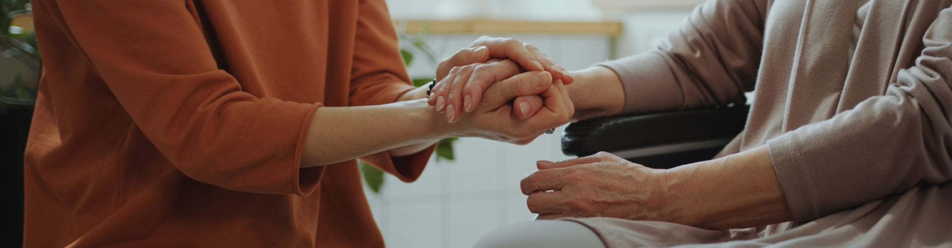 social worker and elderly client holding hands